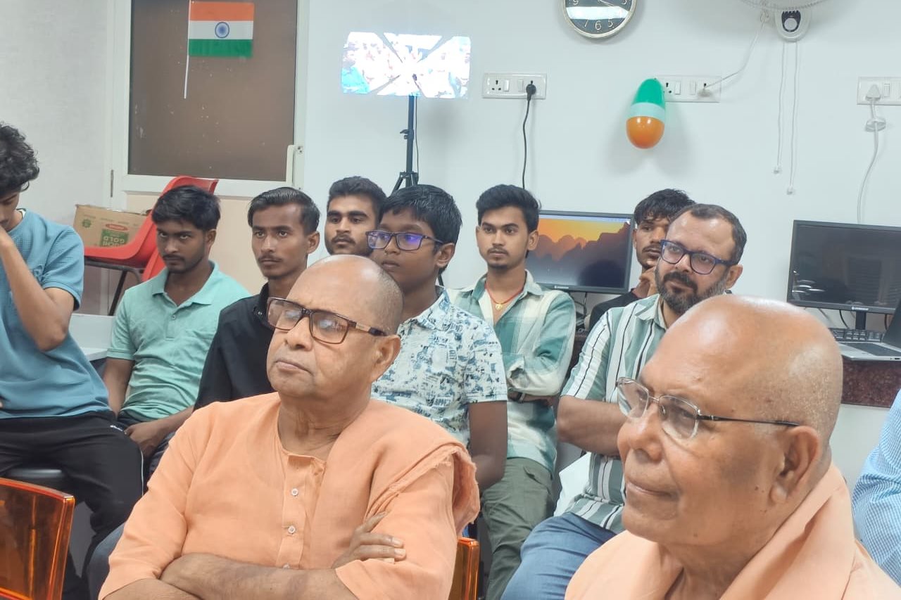 Learners, guests and monks seated together in the lab, watching the launch.